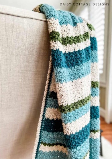 striped throw crochet blanket on the back of a chair